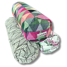 A collection of colorful Tiny Yoga bolster pillows with various patterns.